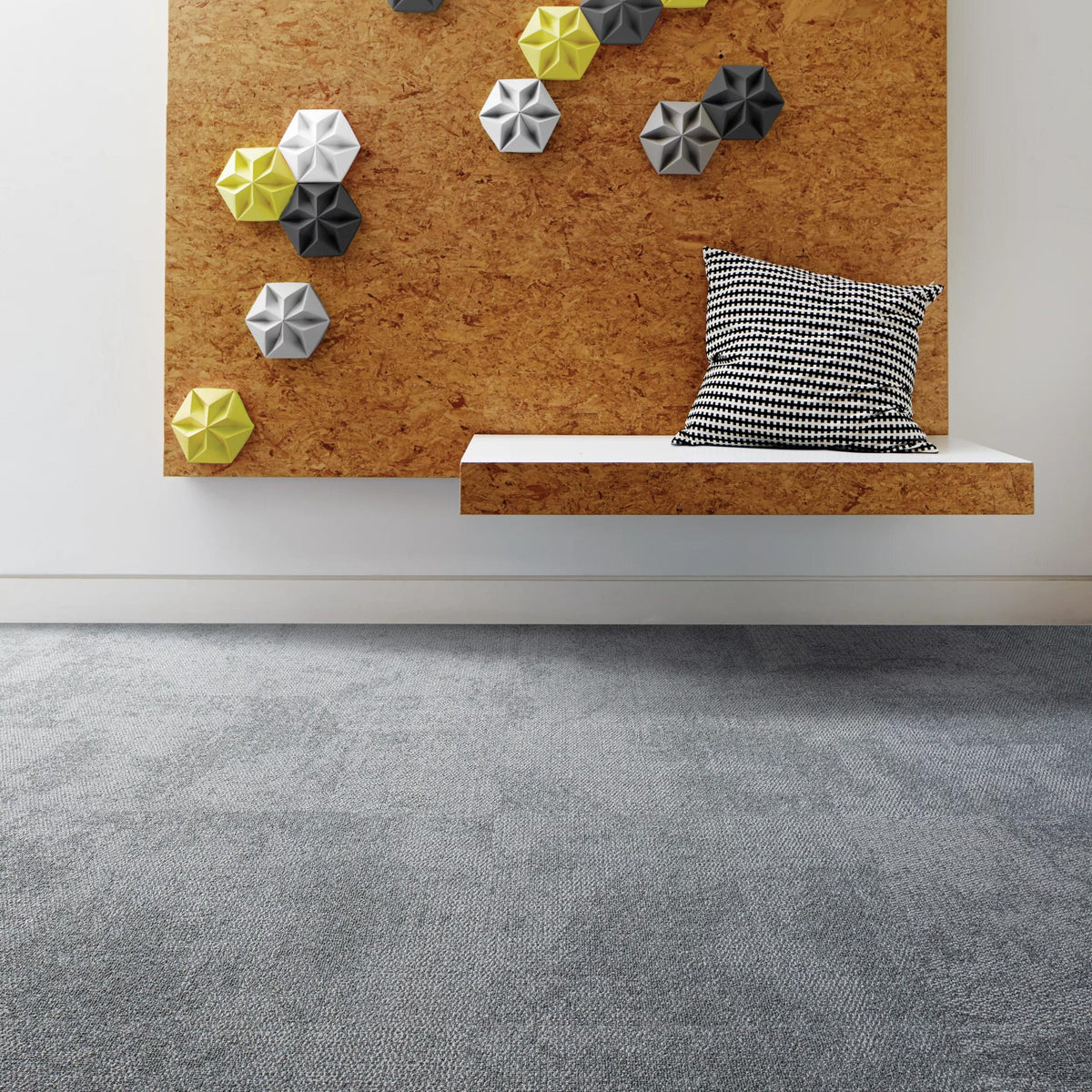 Interface Composure carpet tiles in Isolation below a cork wall with hexagonal accents