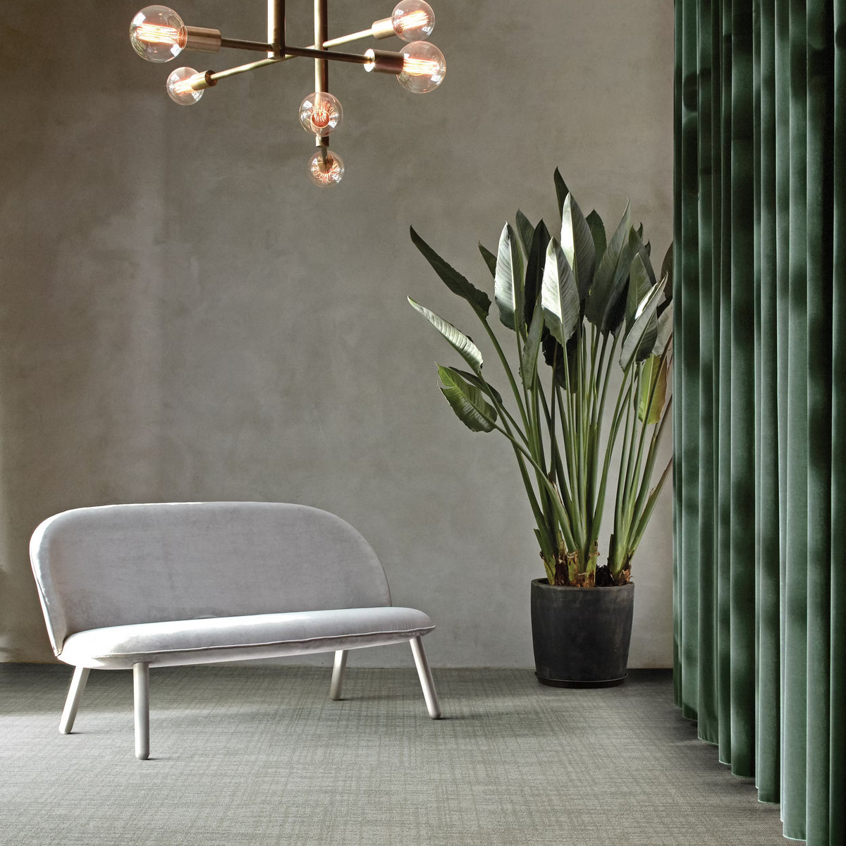 Interface Contemplation carpet tiles in Primitive laid in an ashlar pattern in a lounge with a velvet sofa