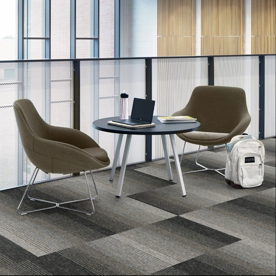 Interface Employ Lines carpet tiles in grey tones in a study area with lounge chairs
