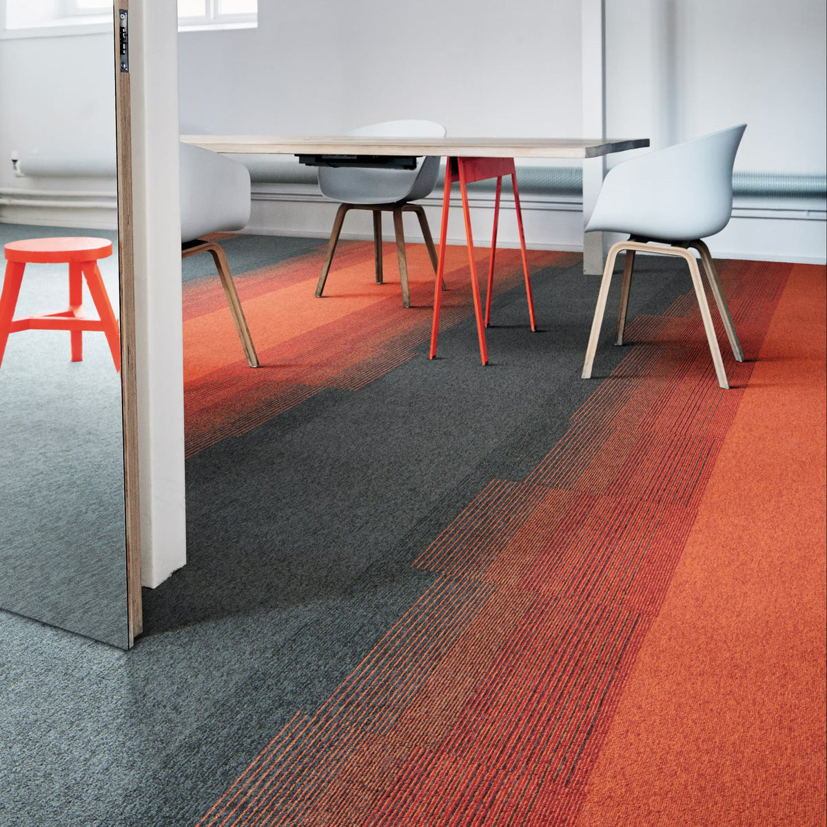 Interface Employ Loop carpet tiles in Shale and Clementine with Employ Lines Sunset in a meeting room