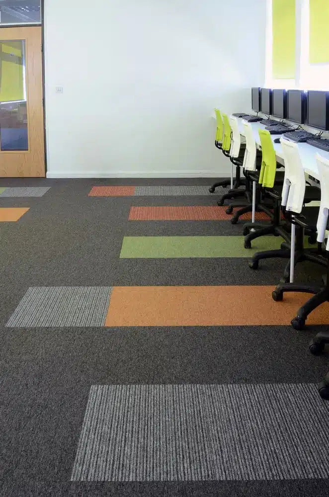 Tivoli® loop pile carpet tiles in the IT room at Hall Park Academy, with orange and green accent tiles - installation example for Tivoli® Carpet Tiles in Volcanic Flame